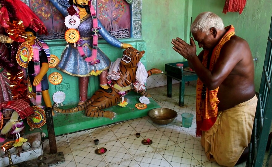 Forest guard Bhabotaron Paik prays in a shrine to the goddess Bonbibi.