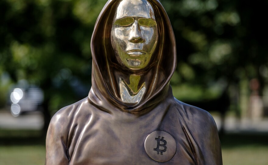 A statue of Satoshi Nakamoto, a presumed pseudonym used by the inventor of bitcoin, is displayed in Graphisoft Park in 2021 in Budapest, Hungary. The statue's creators, Reka Gergely and Tamas Gilly, used anonymized facial features, as Nakamoto's true identity remains unconfirmed.