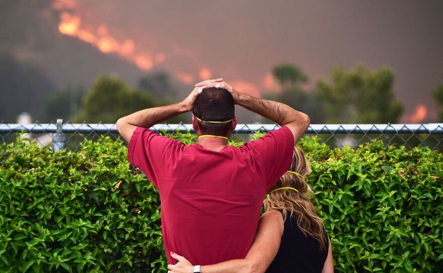 Ziggy Torok and Starla Affatati watch helplessly Thursday as the flames of the Holy Fire close in on Torok's home in the Rice Canyon neighborhood of Lake Elsinore, Calif.