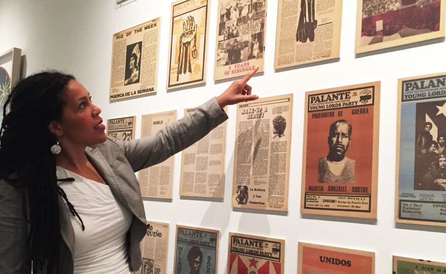 Johanna Fernández, co-curator of a new exhibition about the Young Lords, points to pages of the group's newspaper on display at the Bronx Museum of the Arts.