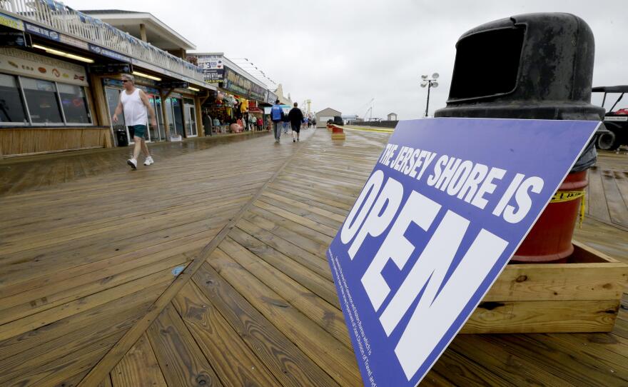 People walk on the boardwalk in Seaside Heights, N.J., on Friday. The Jersey Shore beaches officially opened for the summer, after rebuilding following the destruction left behind by Superstorm Sandy last fall. The storm caused $37 billion of damage in the state.