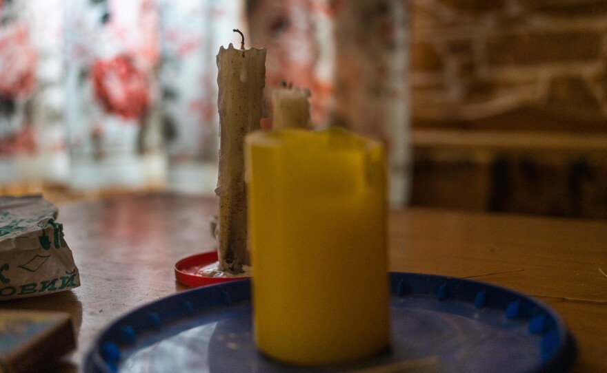 Candles sit on the table in Voinov's home. With the power out, he and other residents live by wood heat and candle light.