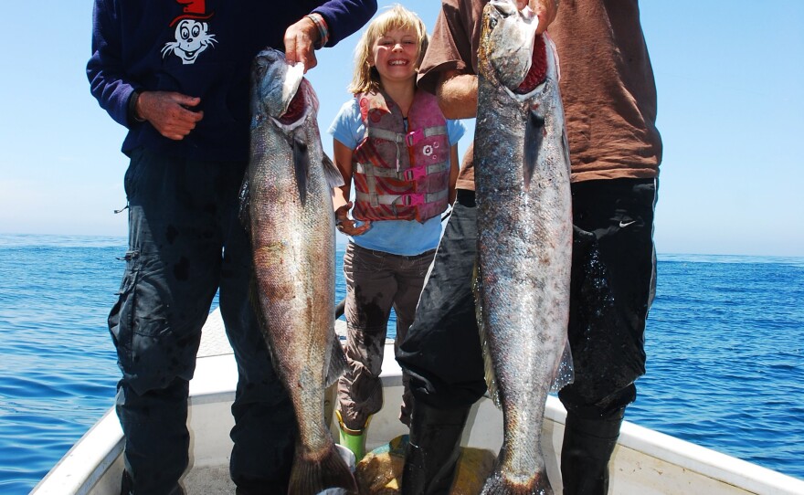Fisherman Eric Hodge (far right) is participating in the pilot Dock to Dish program in California. He's seen here with his father and his daughter Amber, holding white seabass.
