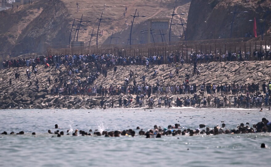 Migrants cross from Morocco into the Spanish enclave of Ceuta, Thursday, July 30, 2026.