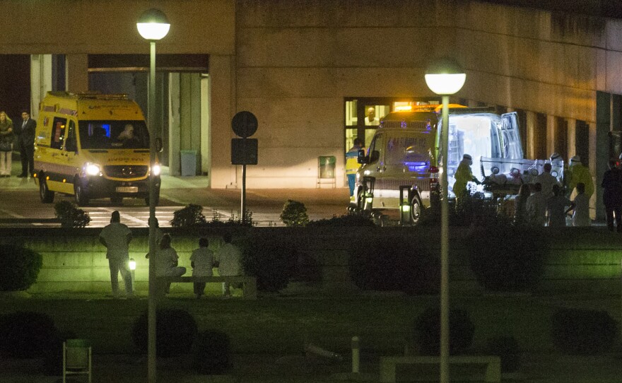 Medical personnel carry a Spanish nurse who is believed to have contracted the ebola virus into an ambulance before they leave Alcorcon Hospital in Madrid, Spain, on Tuesday.