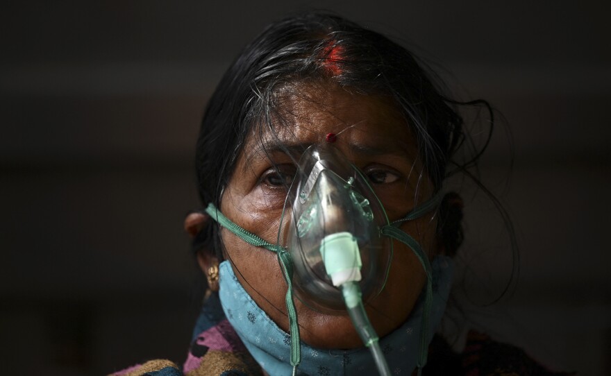 A patient breathes with the help of oxygen provided at tent installed at a gurdwara, a place of worship for Sikhs, in Ghaziabad on May 2.