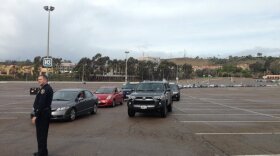 A police officer directs traffic for residents loading sandbags at Qualcomm Stadium, Jan. 7, 2016. 