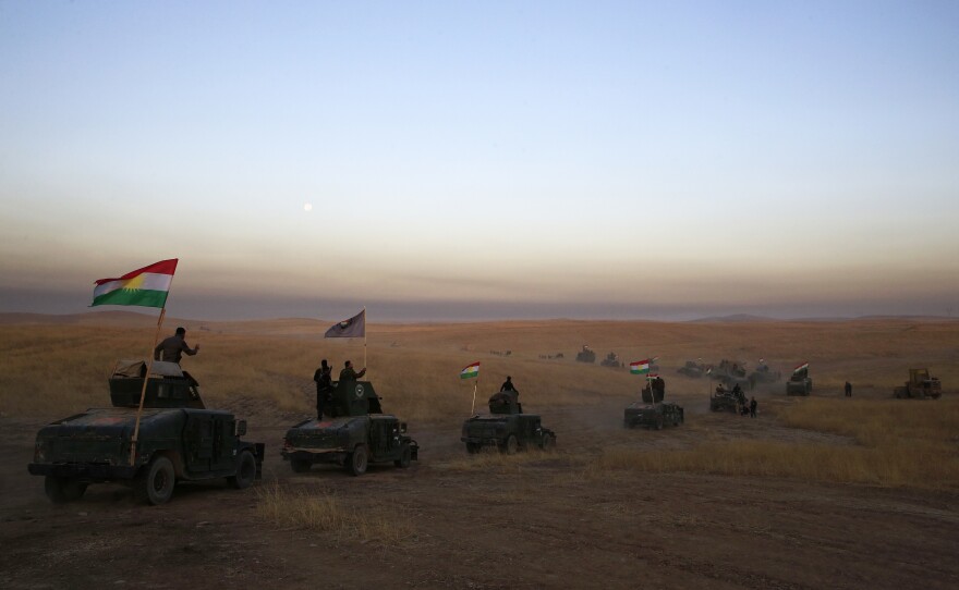 A Peshmerga convoy drives toward a frontline on Monday in Khazer, about 19 miles east of Mosul, Iraq.