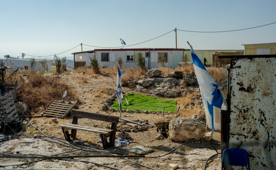 An Israeli flag erected by settlers is seen through the window of the home of Ikhlas al-Hathaleen in the Palestinian village of Umm al-Kheir, in the Masafer Yatta region of the Israeli-occupied West Bank, on Sept. 24, 2026. Israeli military closure orders have restricted the Palestinian family from accessing their courtyard toilet and sheep pen.
