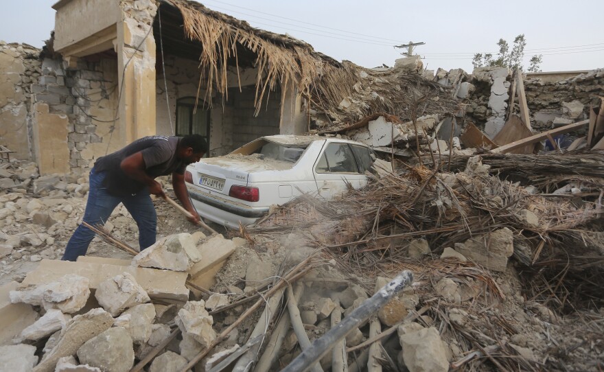 A man cleans up rubble after an earthquake at Sayeh Khosh village in Hormozgan province in Iran, some 620 miles south of the capital Tehran on July 2, 2022.