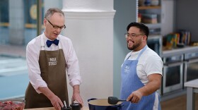 Milk Street Cook Josh Mamaclay (right) shows Christopher Kimball (left) the secret to tender and savory Roman Braised Beef with Tomato and Cloves.