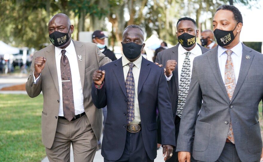 Attorney Ben Crump, left, and Marcus Arbery Sr., the father of Ahmaud Arbery, second from left, arrive at the Glynn County Courthouse in Brunswick, Ga., as jury selection begins for the trial of the shooting death of Ahmaud Arbery on Monday.