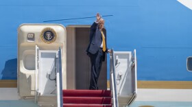 President Donald Trump waves from the doorway of Air Force One at Joint Base Andrews, Maryland, May 12, 2026.