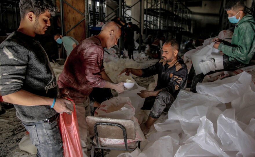 Workers ration out flour during the distribution of humanitarian aid in Gaza City on March 17.