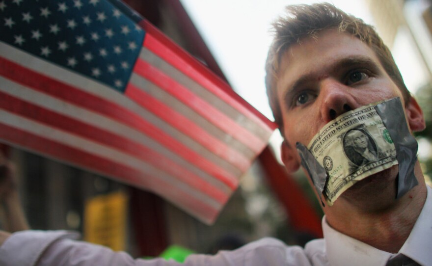 A protester marches on Friday in New York City as part of larger demonstration focused on corporations, wealth and income distribution.