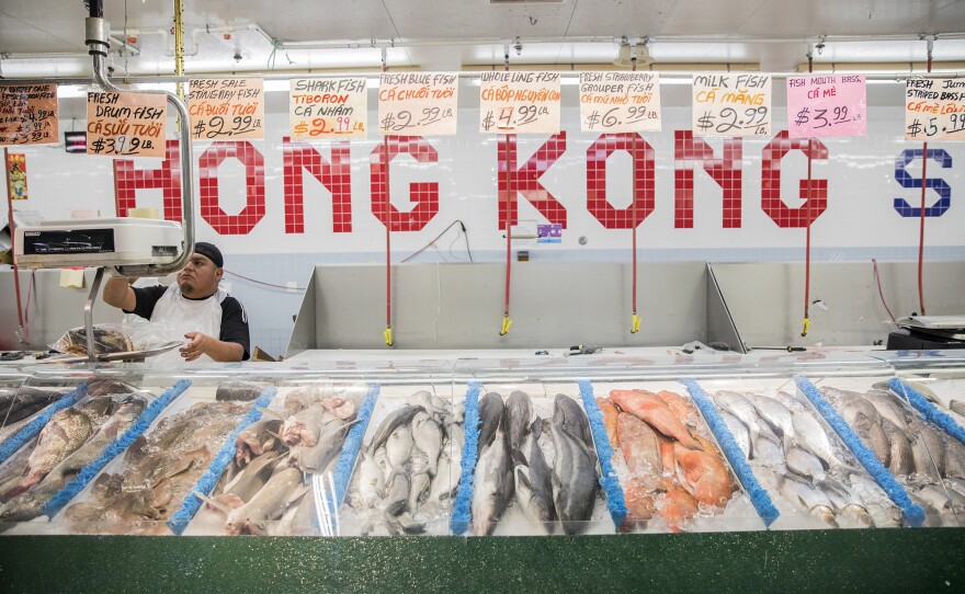 A worker weighs fish at a predominately Vietnamese grocery store.