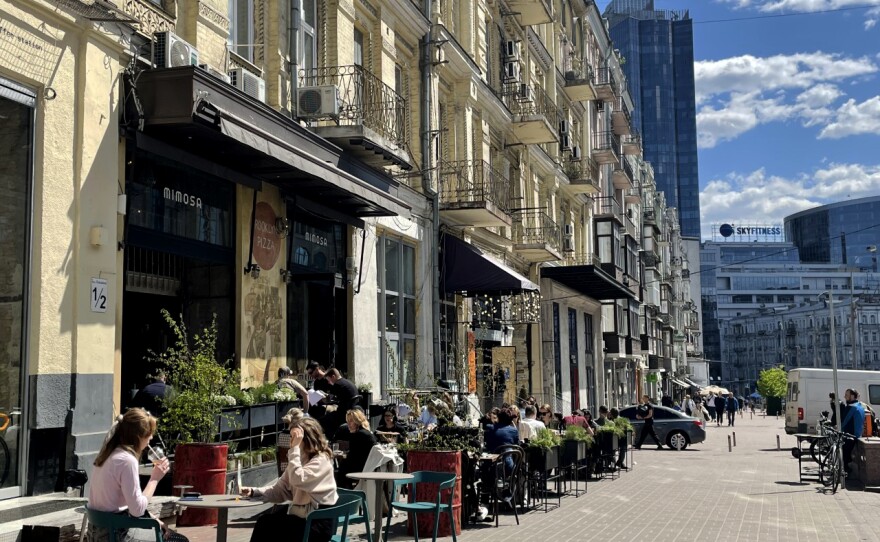 While some parts of the Ukrainian capital have been torn apart by the war, others are unscathed. In downtown Kyiv diners sit outside a pizza restaurant at lunch time.