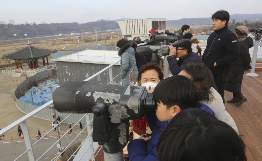 Visitors celebrating the New Year use binoculars to watch North Korean territory Wednesday, near the border between North and South Korea.
