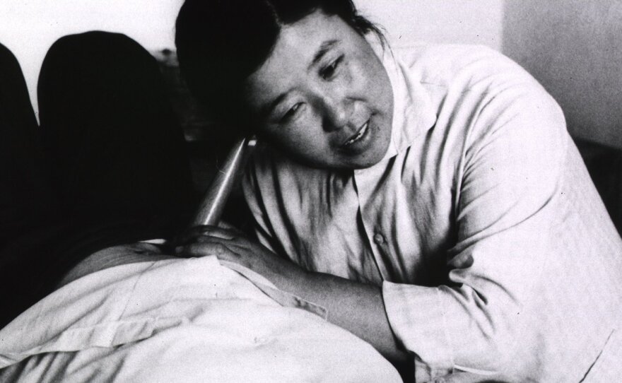 A "barefoot doctor" listens to the heartbeat of a fetus. These community health workers dramatically improved maternal health in China during the 20th century.