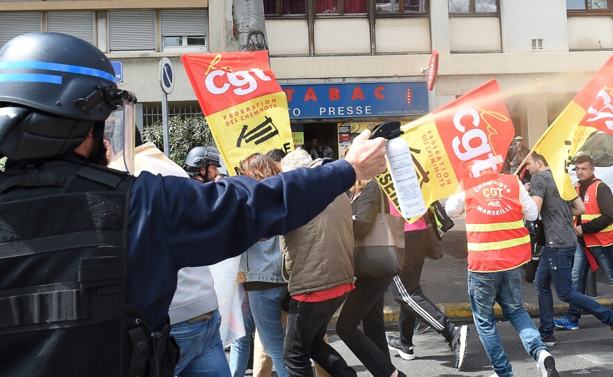 A riot police officer uses pepper spray Wednesday as unionists protest in Marseille, southeastern France.