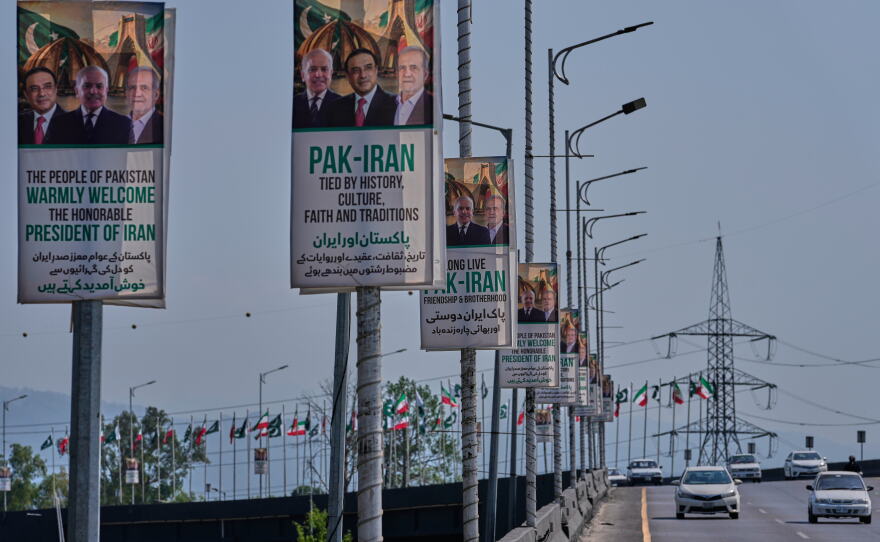 Vehicles drives past welcoming billboards featuring Iranian President Masoud Pezeshkian (right) with Pakistani President Asif Ali Zardari (center) and Prime Minister Shehbaz Sharif alongside an overhead bridge in Islamabad, Pakistan, Tuesday.