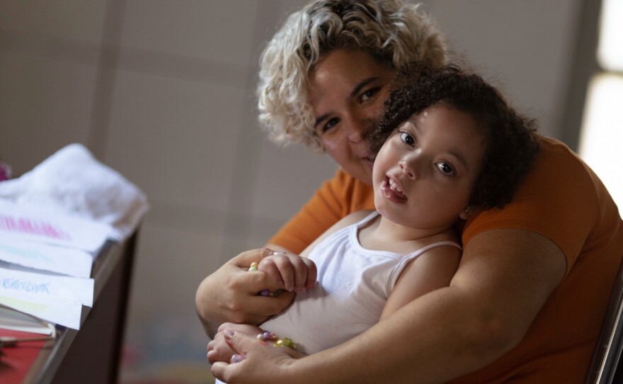 Rochelle dos Santos embraces her daughter, who was born with microcephaly in 2016 after dos Santos contracted Zika during her pregnancy in midwest Brazil.