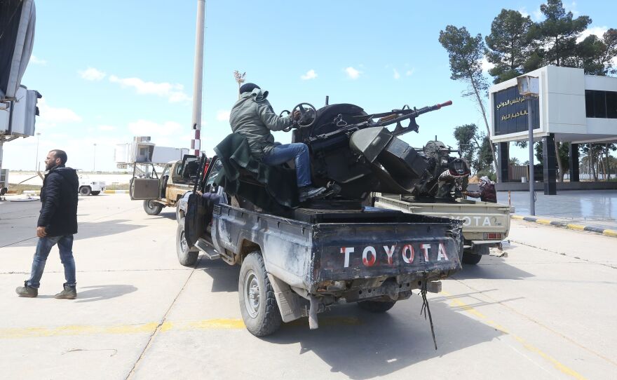 Forces loyal to the internationally recognized Libyan Government of National Accord drive through Tripoli's old airport on Monday. Elsewhere, Libyan strongman Khalifa Haftar's forces struck the city's lone functioning civilian airport, part of his offensive against the capital.