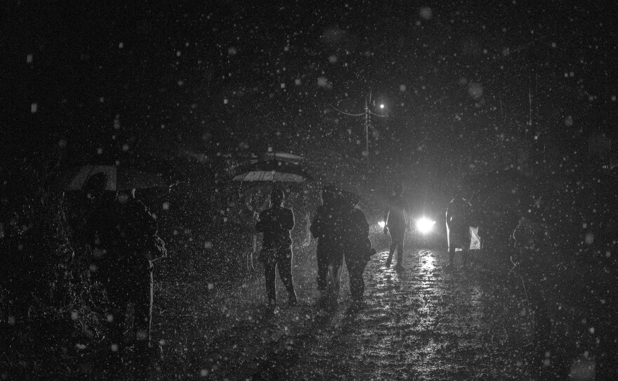 Dozens of people search in the rain for information about their captured relatives around Izalco jail in Sonsonate, a city west of San Salvador, in April 2022. Some people traveled for hours and slept in the street because they lived up to five hours away from the jail.