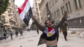 A man holding an Egyptian flag runs through the streets of Cairo. Anti-government protesters have called for Egyptian president Hosni Mubarak to step down.