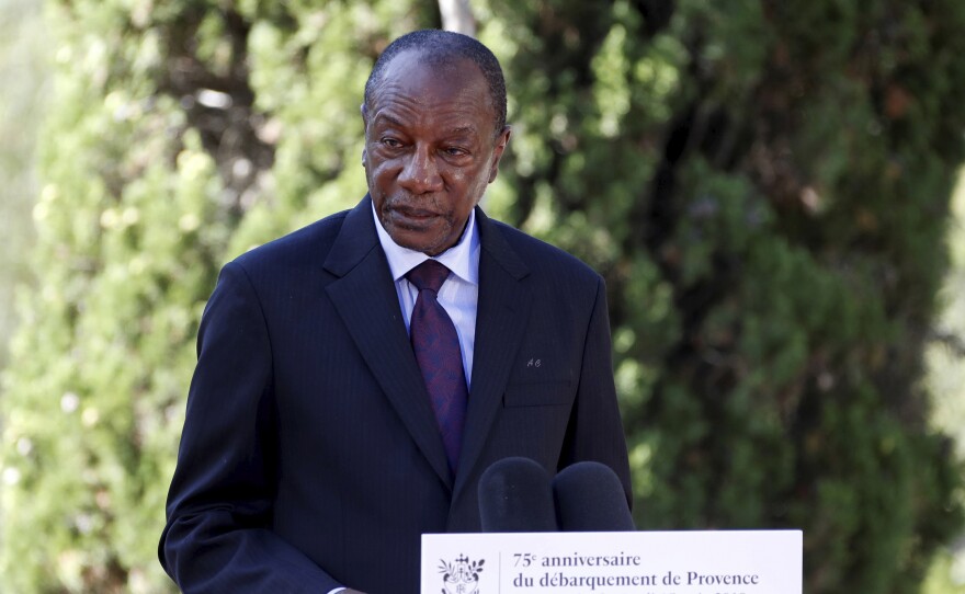 Witnesses say heavy gunfire has erupted near the presidential palace in Guinea's capital and went on for hours. It was not immediately known whether President Alpha Conde, seen above in August 2019, was home at the time the shooting began.