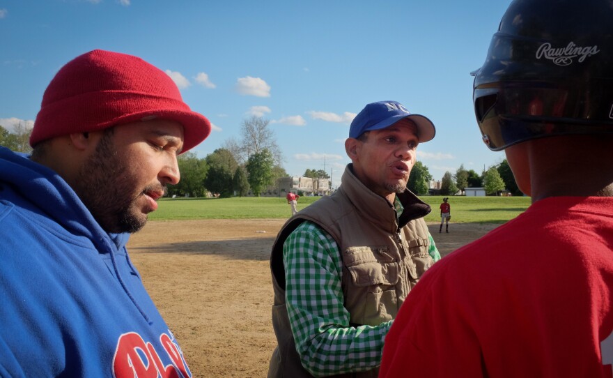 Angel Ramos (left), coach for two of the boys teams, and Bryan Morton (center), president of the league, give a pep talk during a game in Chester, Pa.