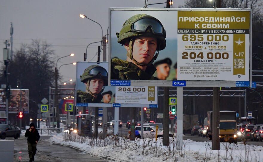 A man walks past billboards promoting contract army service that read "Join yours" in St. Petersburg, Russia, on Dec. 4.