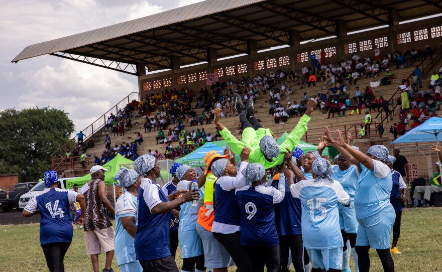The Thulamahashe Grannies, a South African team, hoist a player into the air after their 1-0 victory over Kenya's Mutei Grannies.