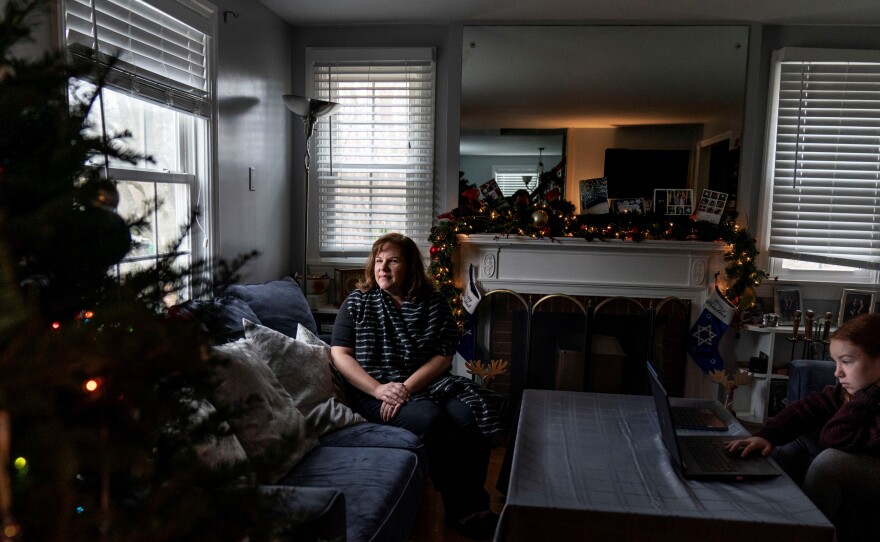 Eileen Carroll, left, sits for a portrait as her daughter, Lily, 11, attends school remotely from their home in Warwick, R.I. on Dec. 16. When Carroll's other daughter tested positive for the coronavirus, state health officials told her to notify anyone her daughter might have been around. Contact tracers, she was told, were simply too overwhelmed to do it.