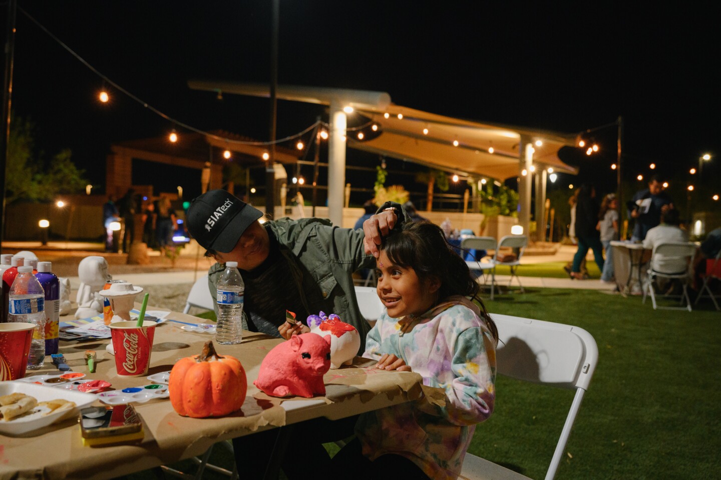 Imperial resident Vanessa Quezada brushes back the hair from her daughter, Abby Guardado's face at the painting station during an information event organized by the ACLU’s Imperial Valley team, along with five other local advocacy organizations, on Oct. 18, 2024. The coalition is hoping to register hundreds of new voters and get people energized about casting their ballots ahead of the November election.
