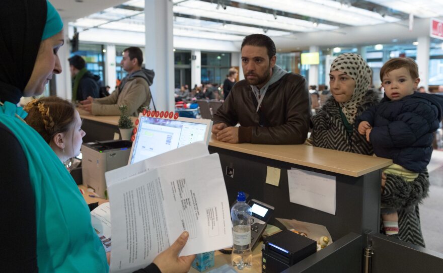 A family from Syria speaks with a language professional (left) about their application for asylum.