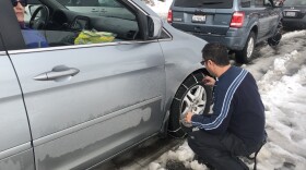 A man putting on chains on Sunrise Highway before heading to Mount Laguna on Nov. 29, 2019.
