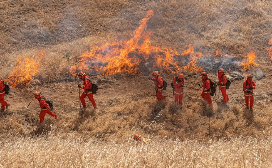 California inmate firefighters approach a controlled burn at Eastman Lake in Madera County in May 2021.