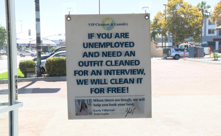 A sign announcing free dry cleaning for unemployed job seekers is shown in the VIP Cleaners window on August 17, 2026.