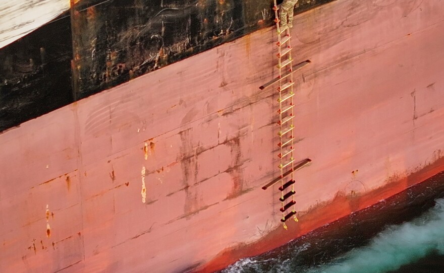 In this photo released by Tasnim News Agency, Revolutionary Guard Navy (IRGC) armed men climb aboard the cargo ship MSC Francesca during what state media described as the seizure of one of two vessels accused of violations in the Strait of Hormuz, April 21, 2026.