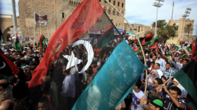 Libyans wave their new national flag as they celebrate in the streets of Tripoli following news of Moamer Kahdafi's capture on October 20, 2011. 