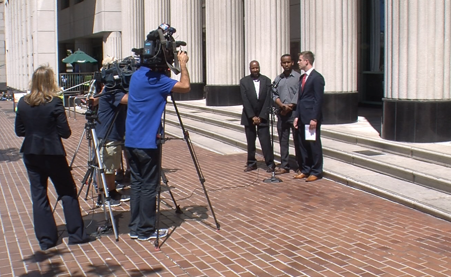 Cabdriver Abdikadir Abdisalan and Institute for Justice Attorney Keith Diggs talk to the press outside of the Hall of Justice, where a judge heard arguments for and against an injunction on the city's plan to issue more taxi permits, April 28, 2015.