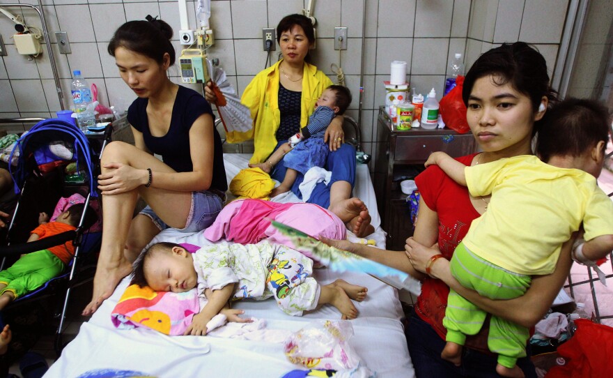 Measles brought these kids to a state-run hospital in Hanoi, where their family members offer comfort.