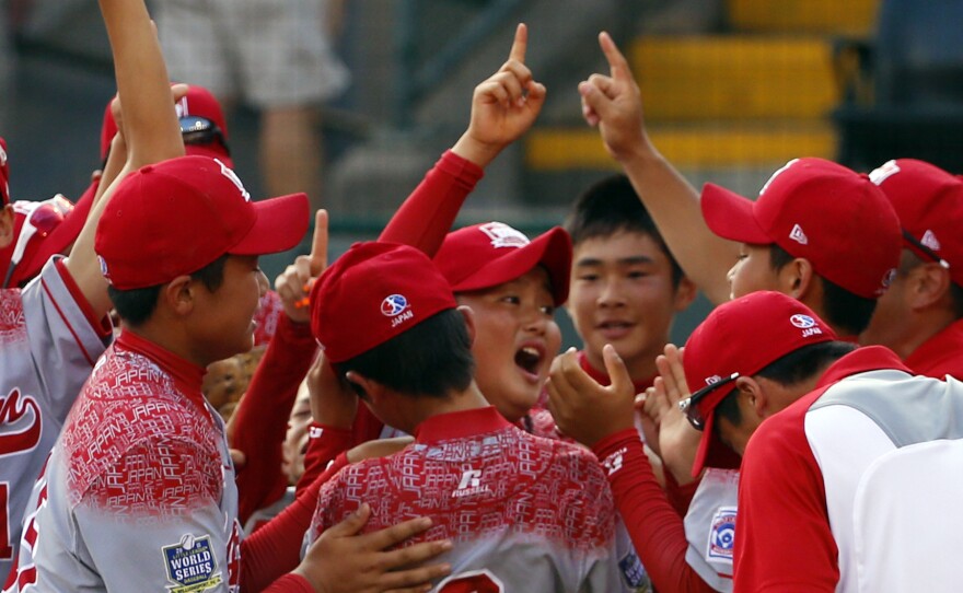 Japan celebrates after erasing an eight-run deficit to win the Little League World Series Championship baseball game, 18-11.