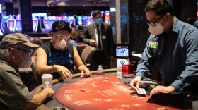 Two visitors wear face shields and masks while at a card table at the Sycuan Casino in East County, Aug. 14, 2020.