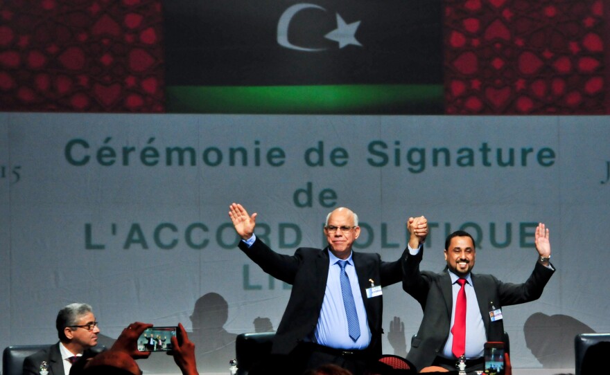 Delegates from the Libyan political dialogue participants raise their hands at the signing ceremony of the Libyan Political Agreement in Skhirat, Morocco, on Friday.