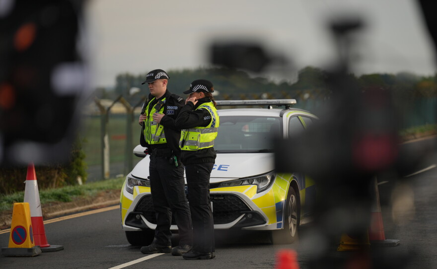 Police officers guard a road leading to RAF Fairford, after an incident in Fairford, England, Monday Sept. 28, 2026.