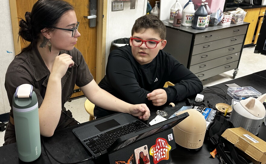 Boyer and Hoy work on some last-minute adjustments to his AI-powered SkoBot before presenting at his school's end-of-year showcase, called the STEAM Museum.