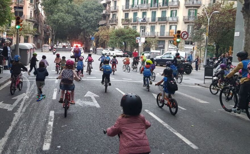 Children joining the <em>bicibus</em> in the Eixample district of Barcelona make their way to school on a recent Friday morning. The community is hoping to build a school-friendly bike lane for a safer commute for kids.