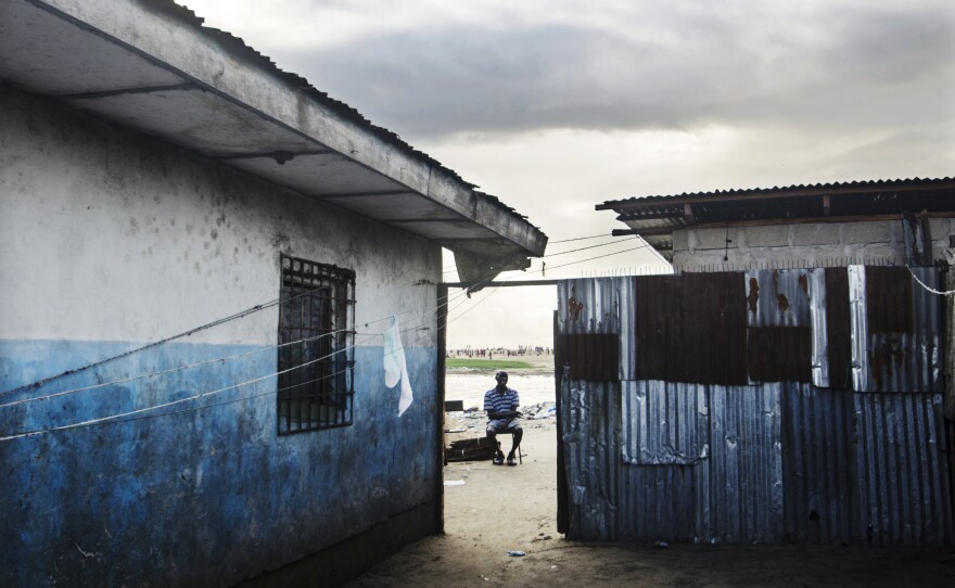 A resident takes in the view from this Liberian slum.